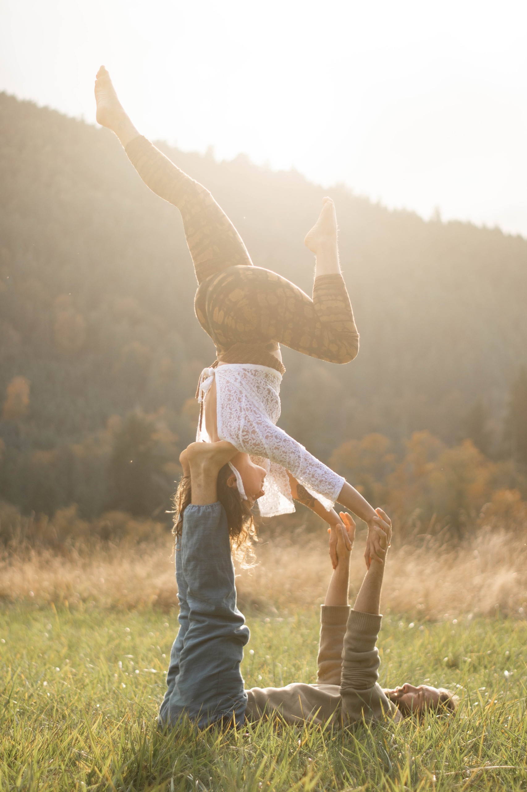 Couple acro yoga au coucher du soleil